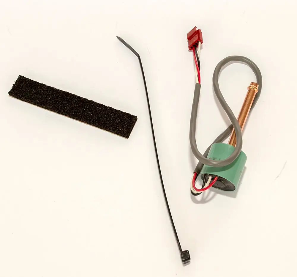 Daikin Drucksensor mit einem kupfernen Element, verbundenen Drähten, einem Anschlussstecker und einem Kunststoffelement sowie einer schwarzen Struktur.
